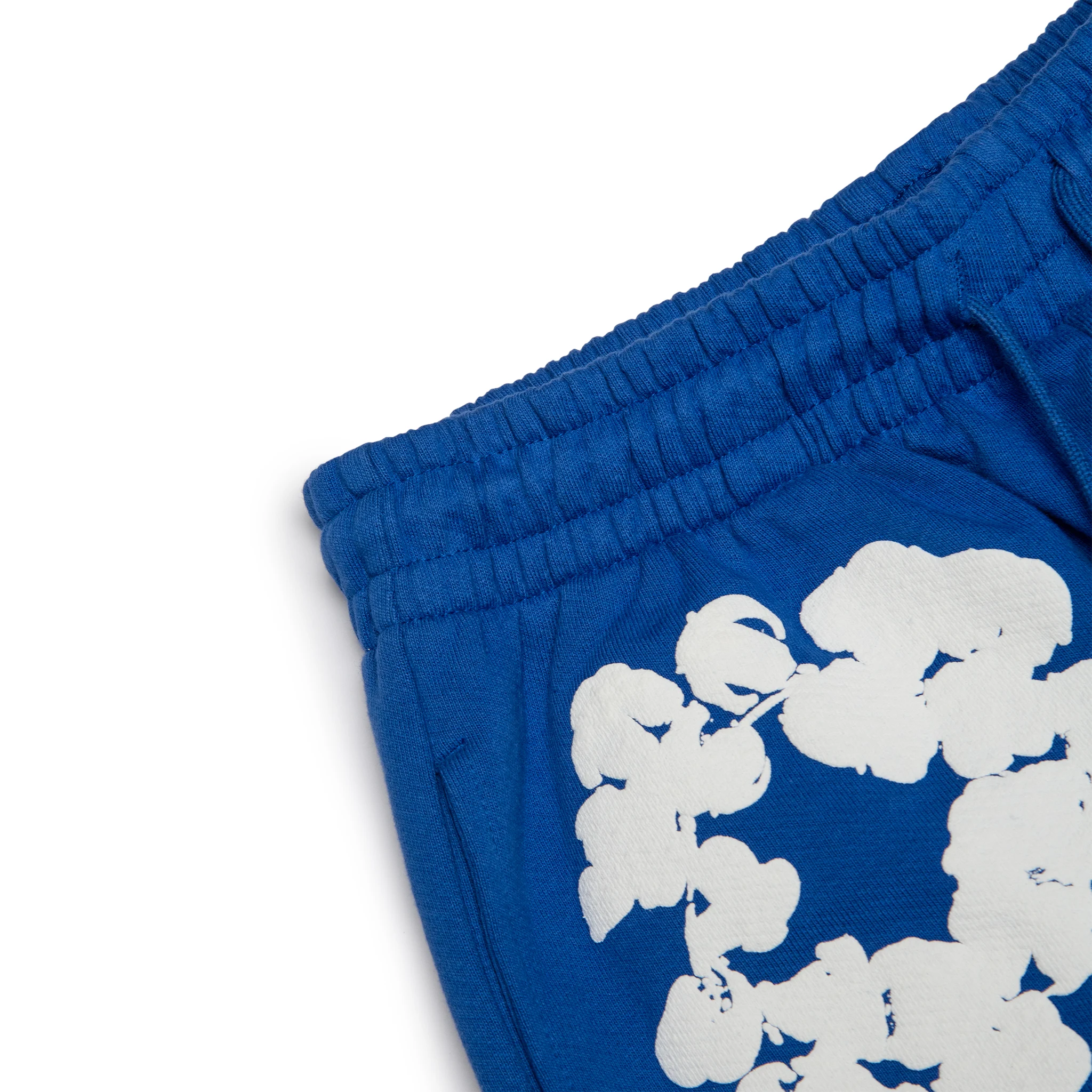 Corner view of Denim Tears The Cotton Wreath Royal Blue Sweatpants